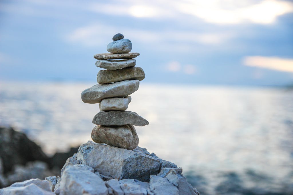 Peaceful stone stack by a serene ocean, symbolizing balance and tranquility.